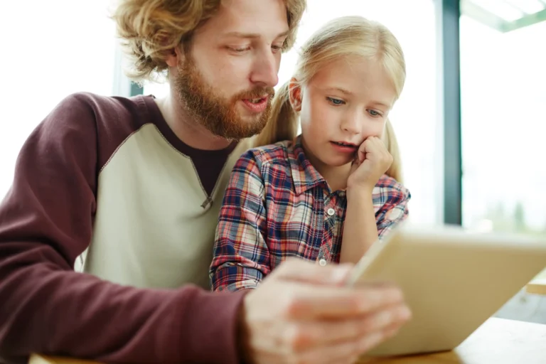 dad teaches daughter on tablet