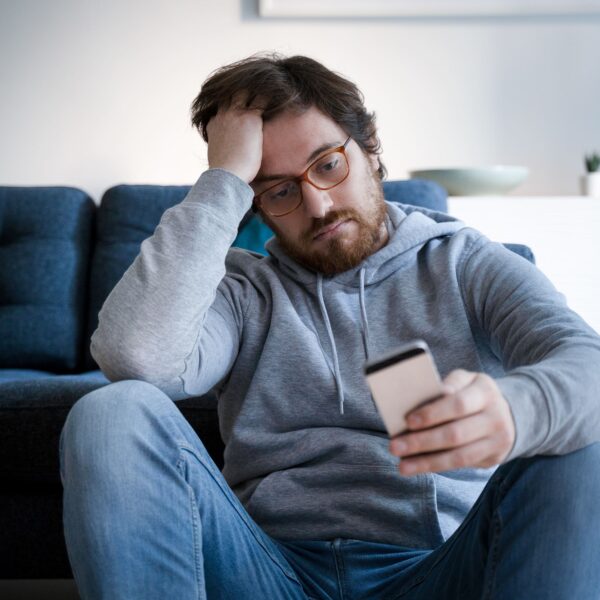 man looks stressed looking at phone scaled e1635092029412