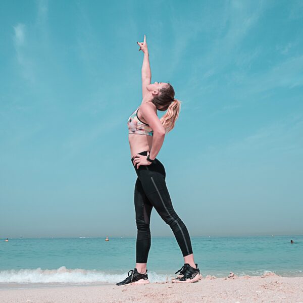 woman on beach points to the sky scaled