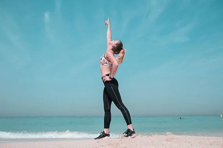 woman on beach points to the sky scaled