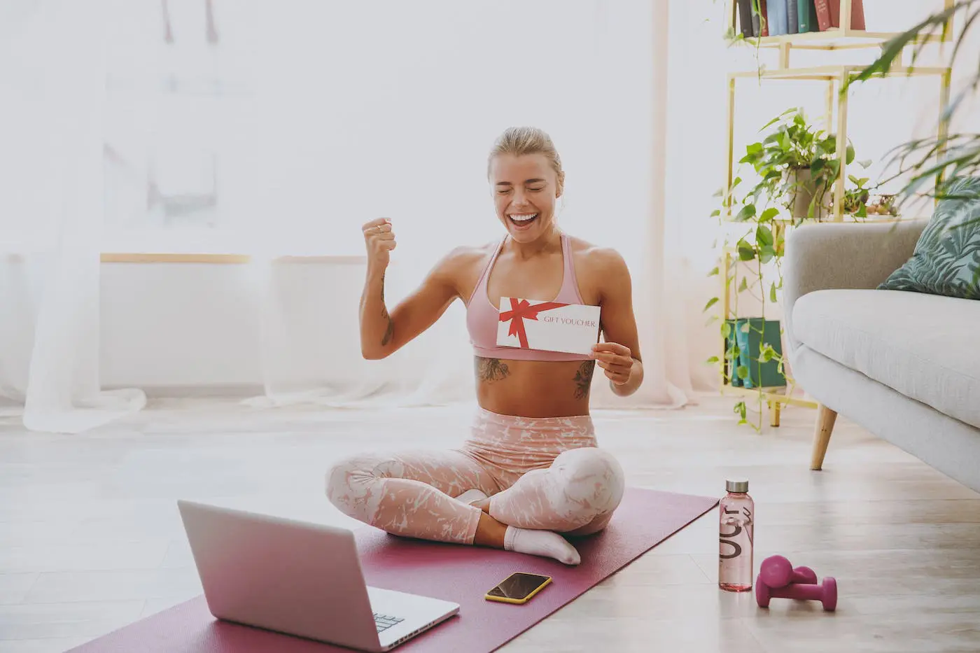 Young fit woman holds gift voucher