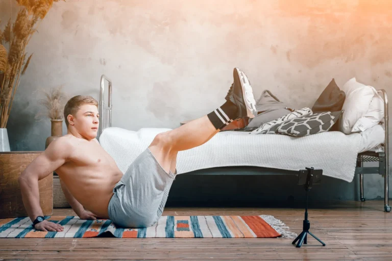 young man fitness at home lifting his legs up scaled