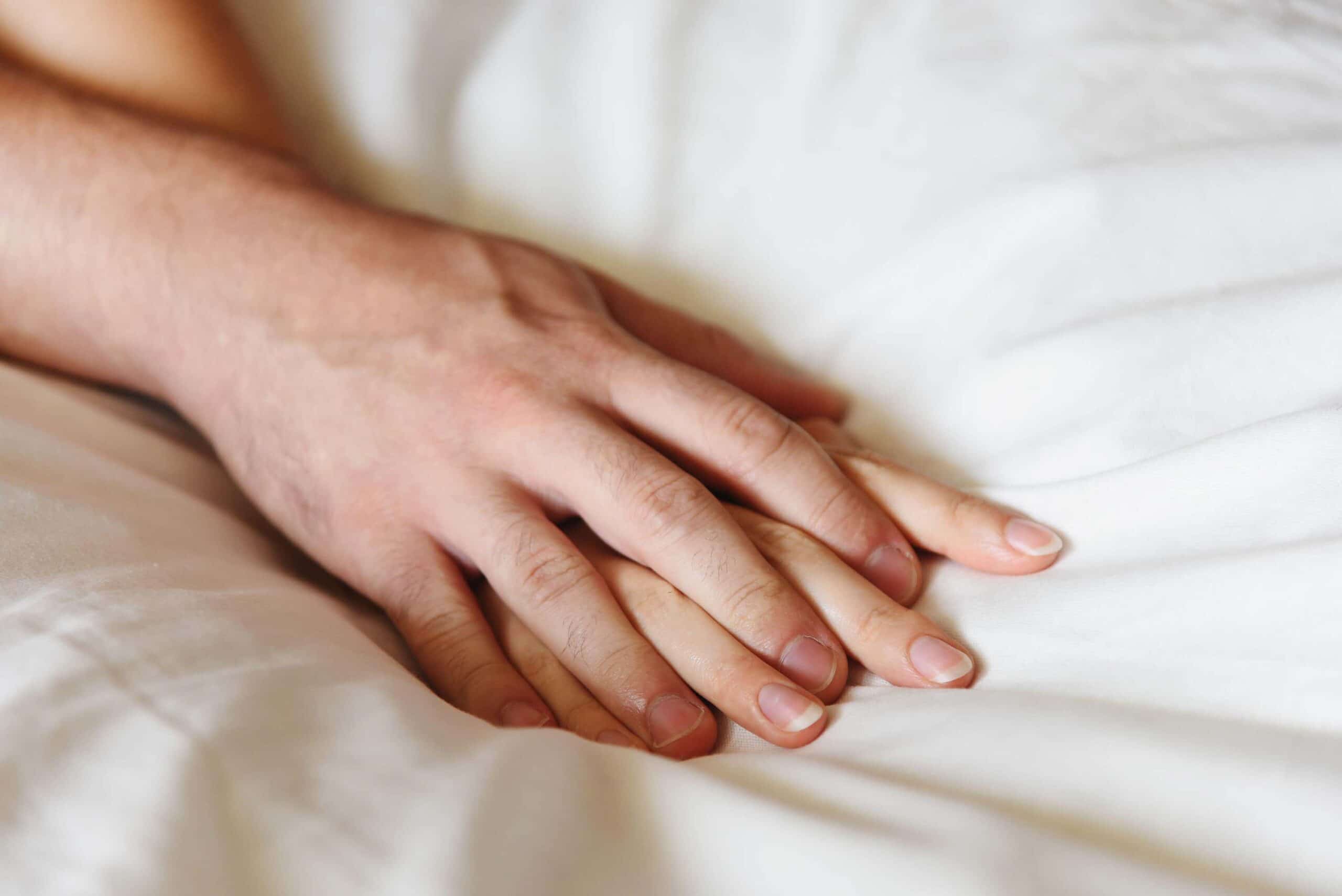 Pair of hands on bed scaled