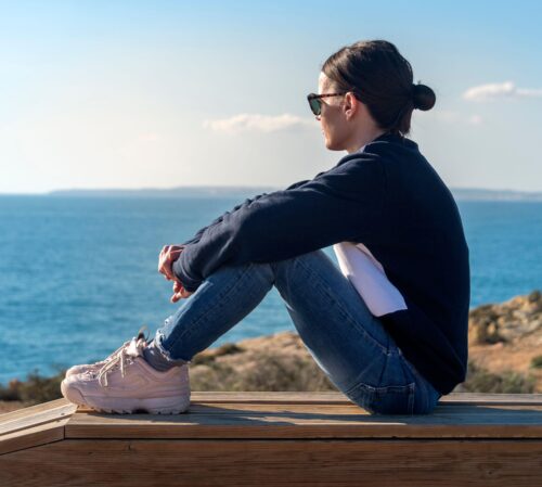 woman sits by the sea scaled