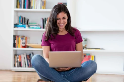 woman sits in front of laptop scaled