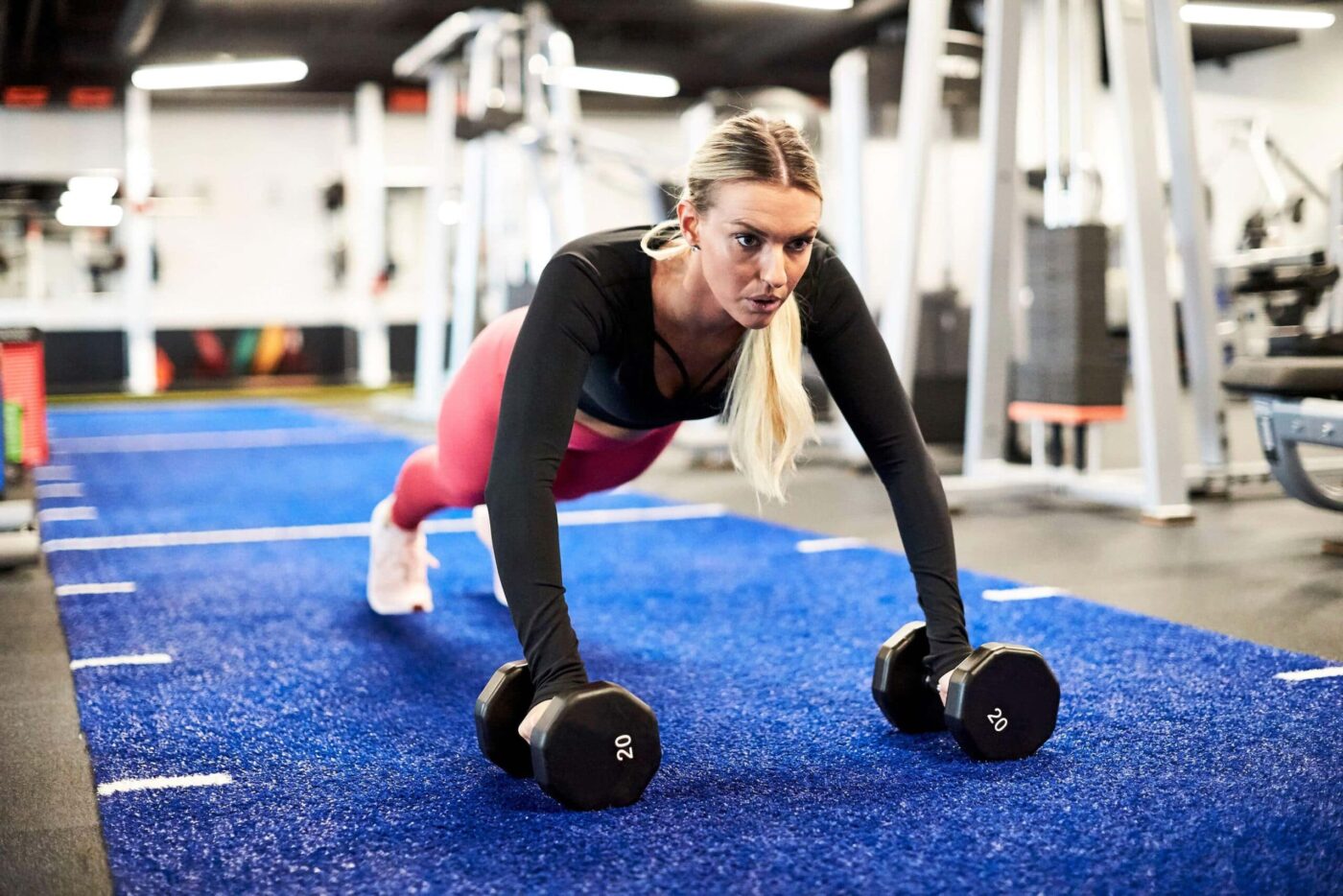 Fit woman using dumbbells to do push ups scaled e1630001100682