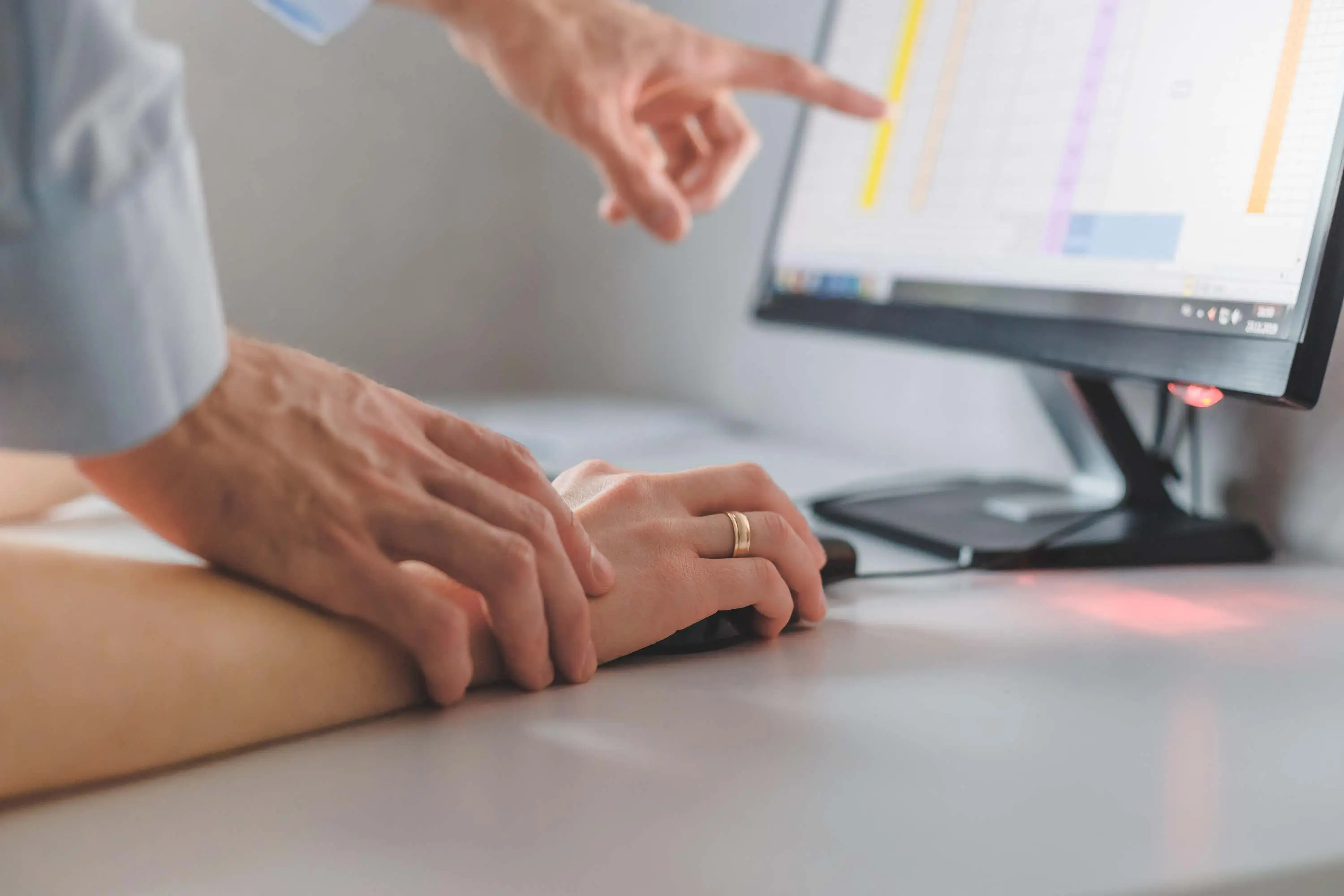 Hand holds wrist of person in work scaled