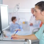 medical assistant looks at screen