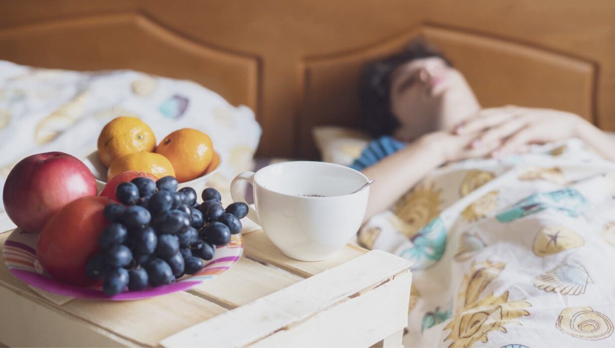 person asleep with fruit by bedside