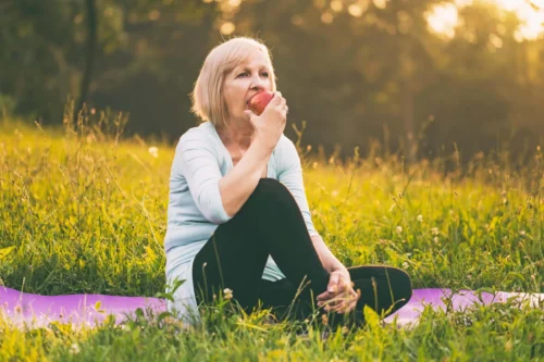 woman on picnic blanket eats apple scaled