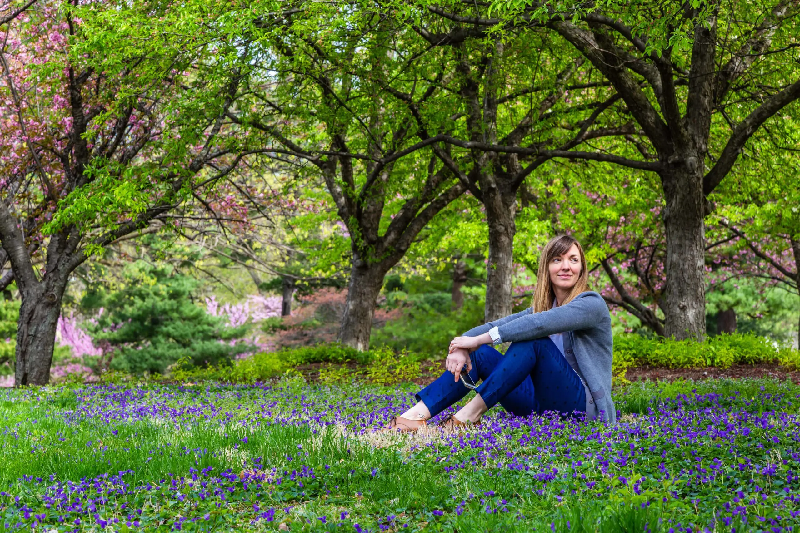 Woman sits in blossoming field scaled