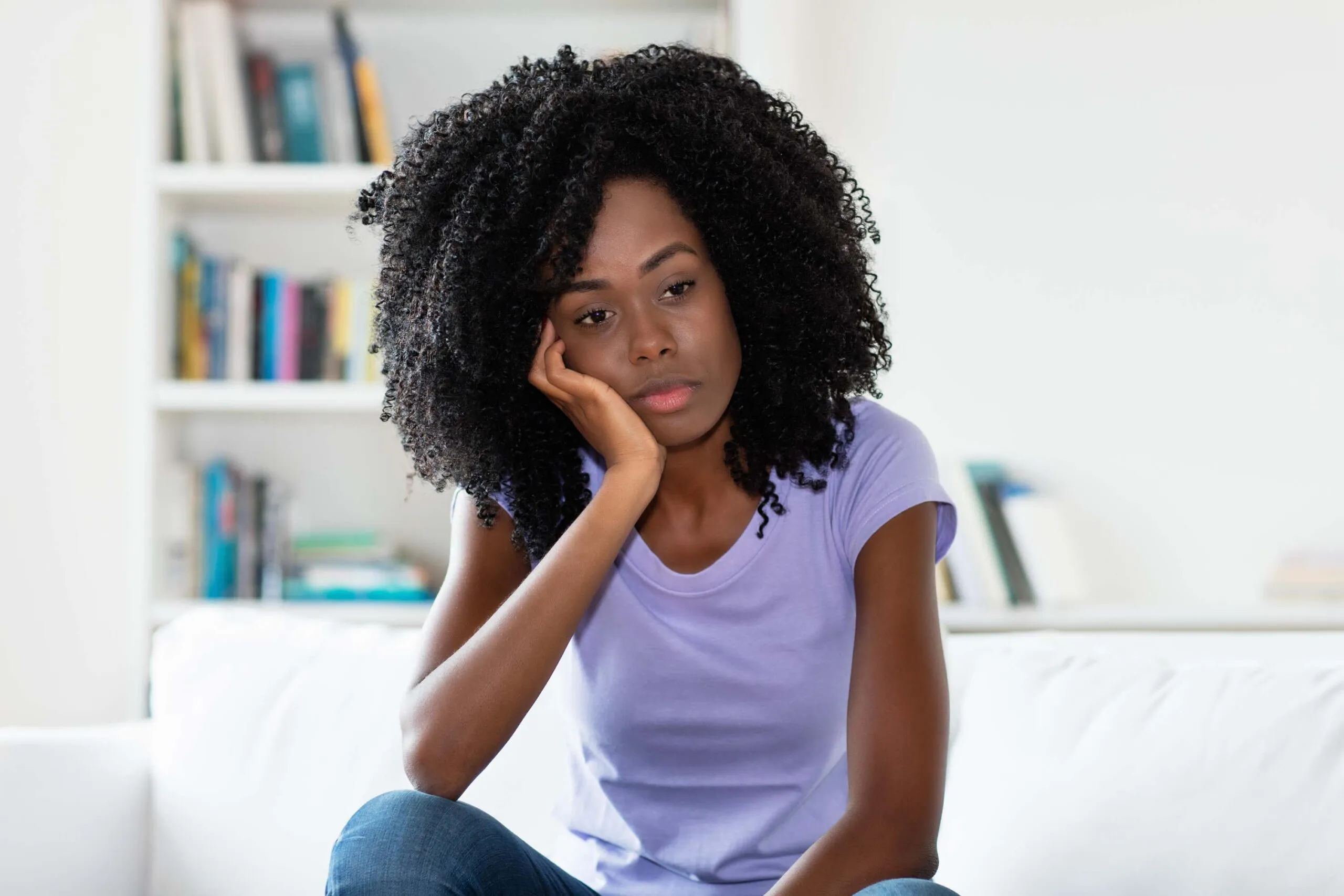 woman sits looking sad scaled