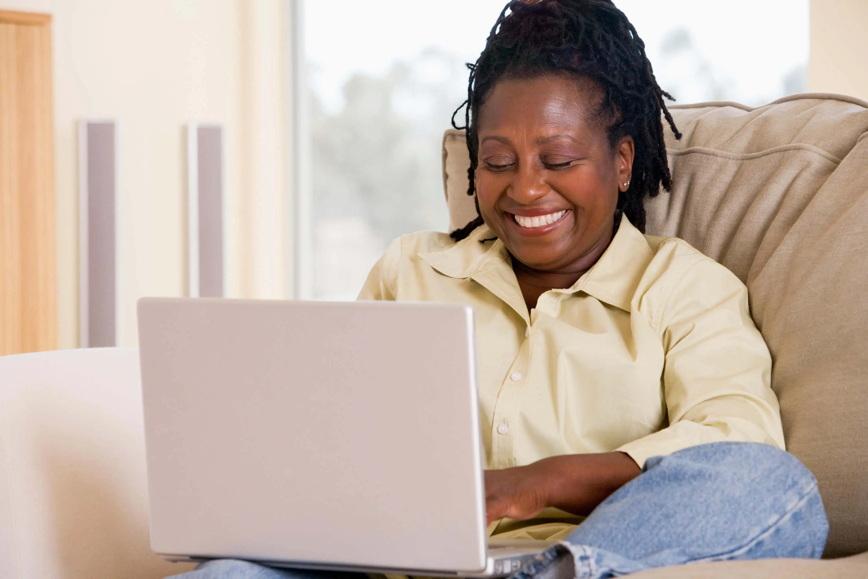 Woman smiles on laptop scaled