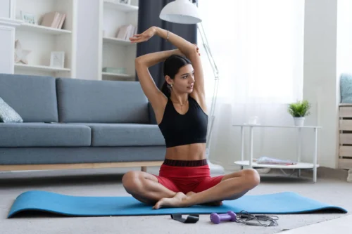 woman stretches on yoga mat
