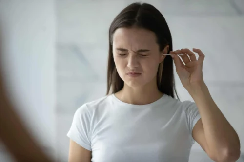woman with earbud in ear scaled