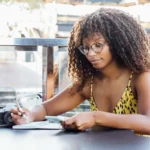 woman writes on pen and paper scaled