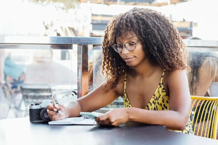 woman writes on pen and paper scaled