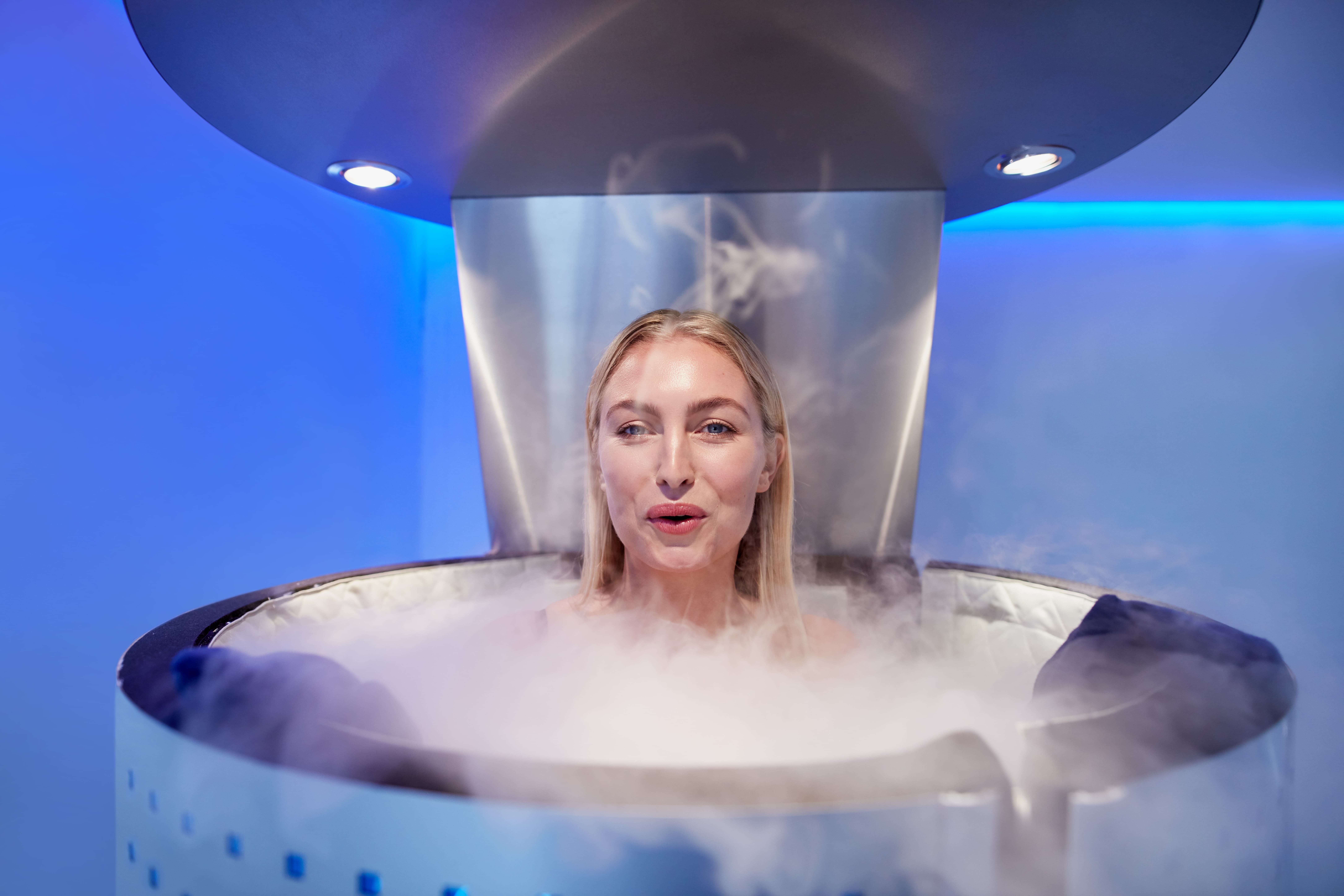 Woman in a whole body cryotherapy cabin e1660388775570