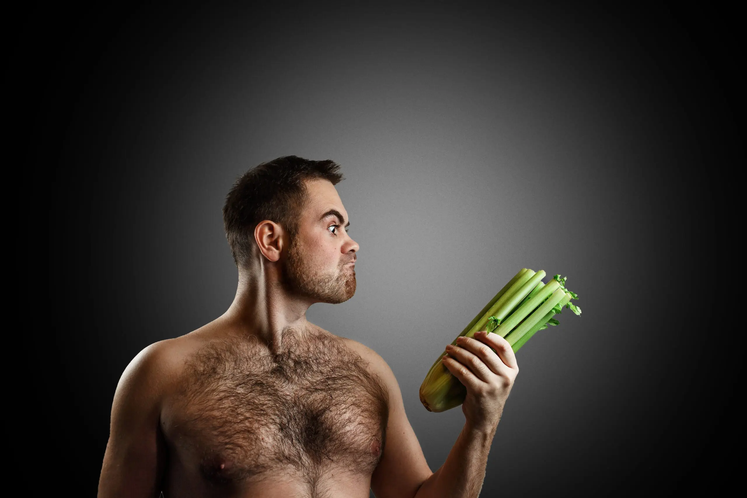 man looks intensely at celery scaled