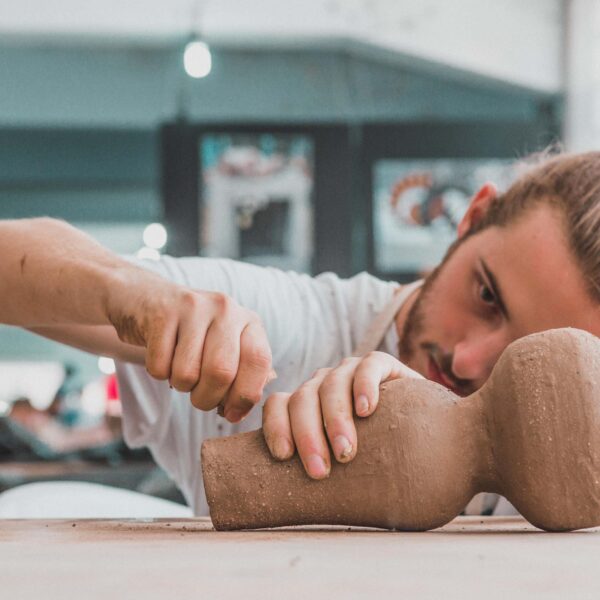 man works on pottery scaled