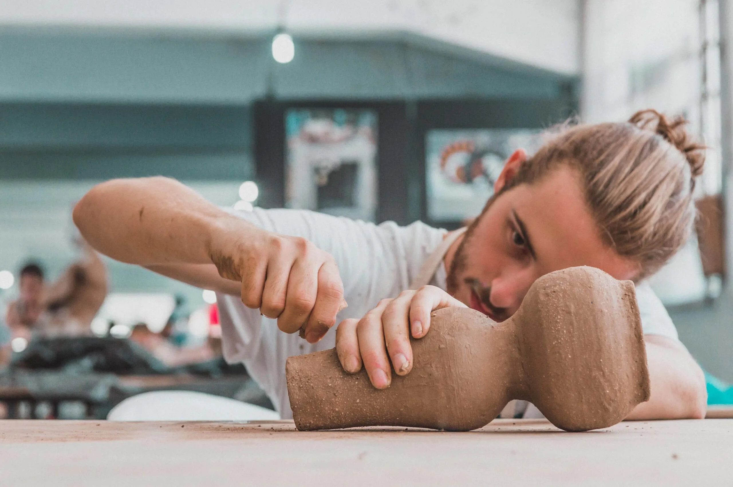 man works on pottery scaled