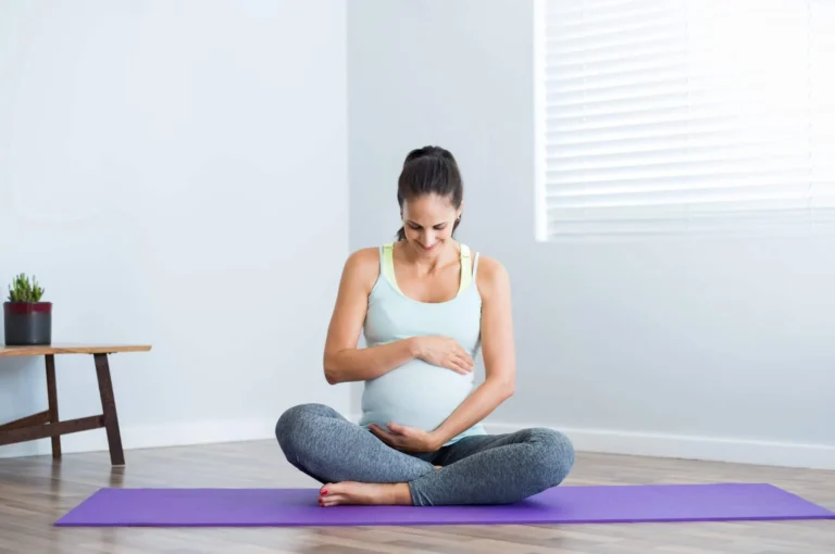 pregnant woman sitting on yoga mat scaled