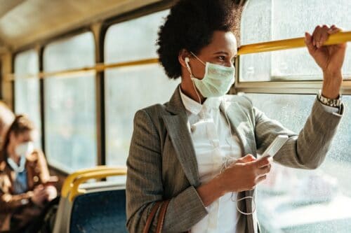 woman holds rail on bus scaled