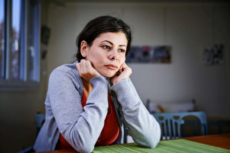 woman sits looking sad