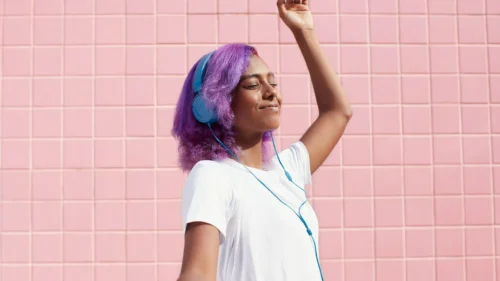 woman with colourful hair listens to music