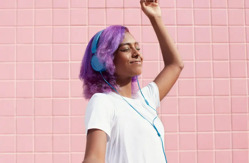 woman with colourful hair listens to music