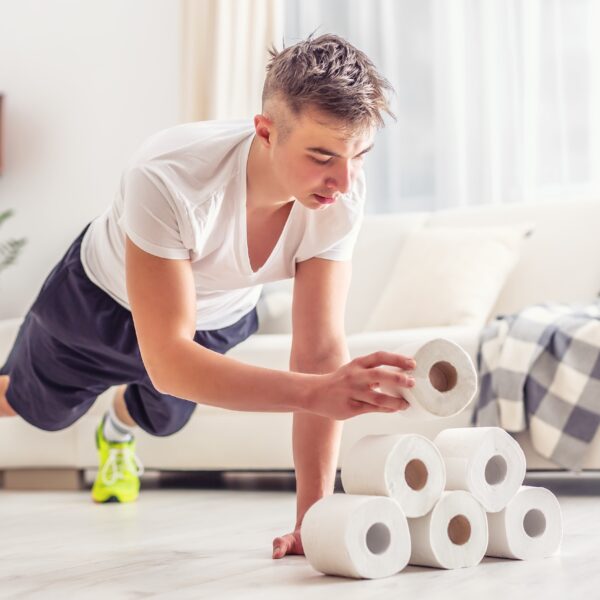 young man holding a plank whilst stacking toilet roll