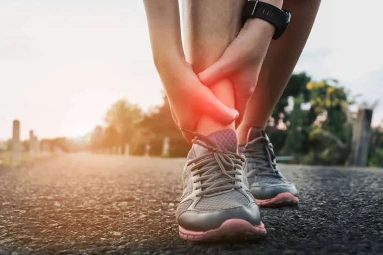 athlete holds ankle in pain