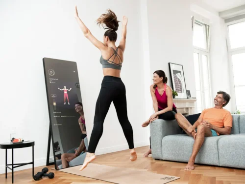 woman exercises in front of fitness mirror