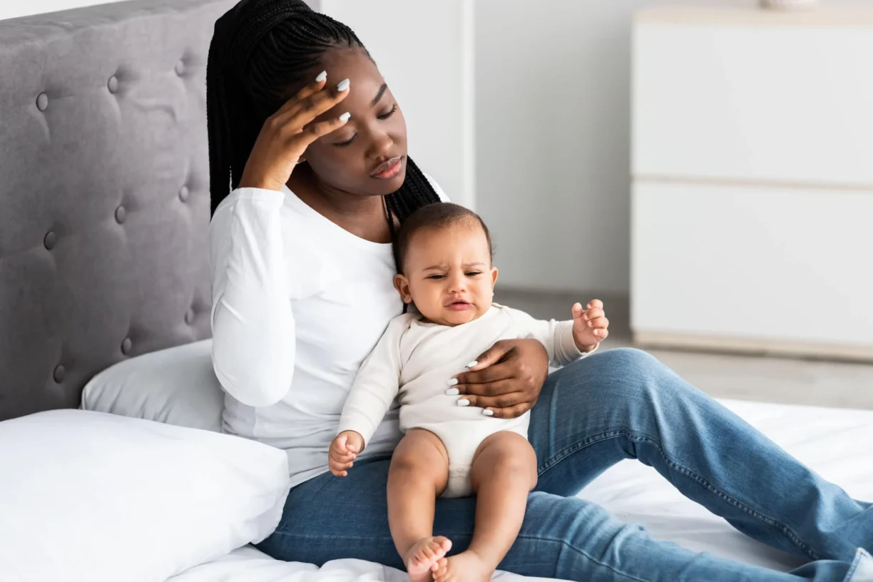 woman looking tired holding baby