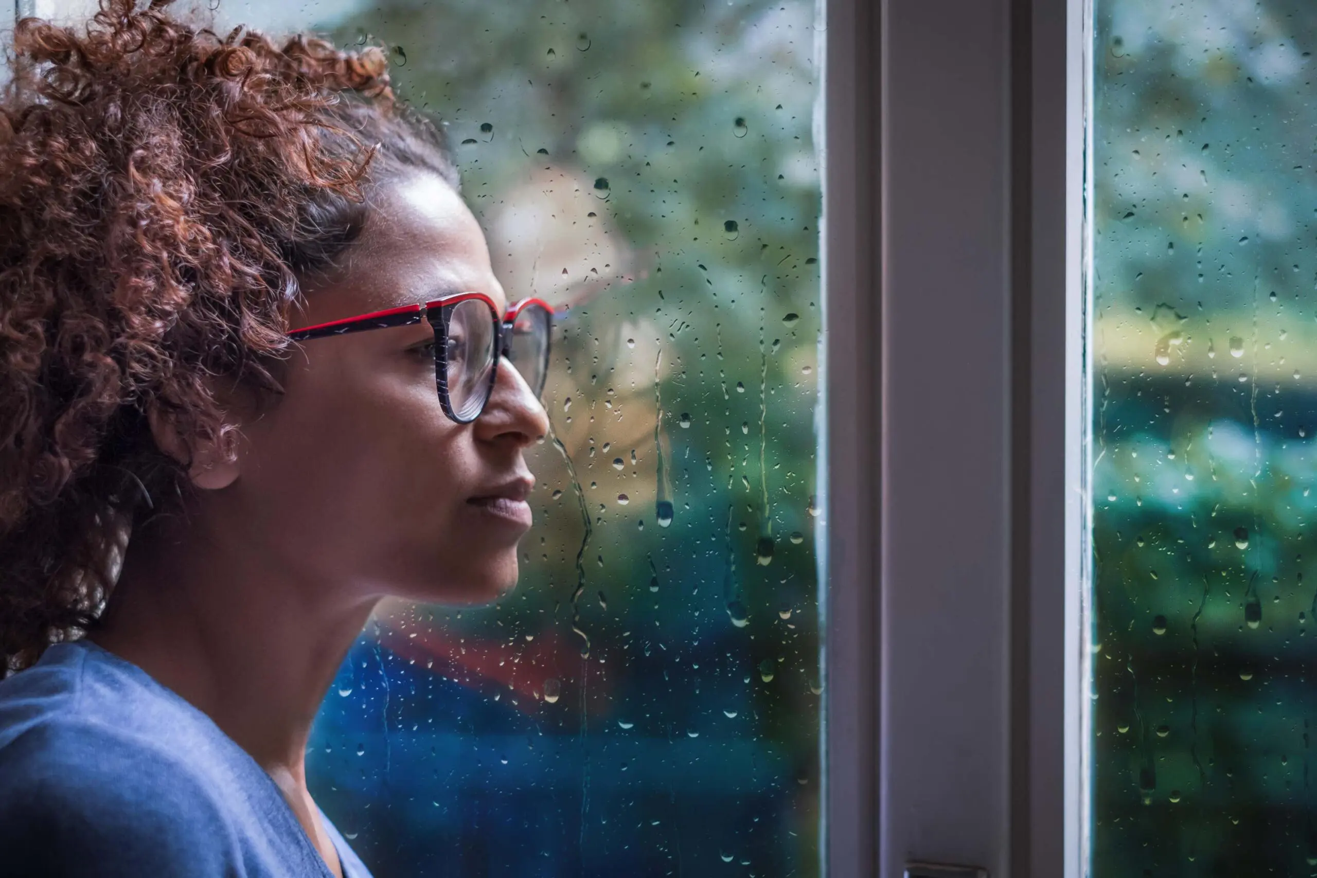 Woman looks out window scaled