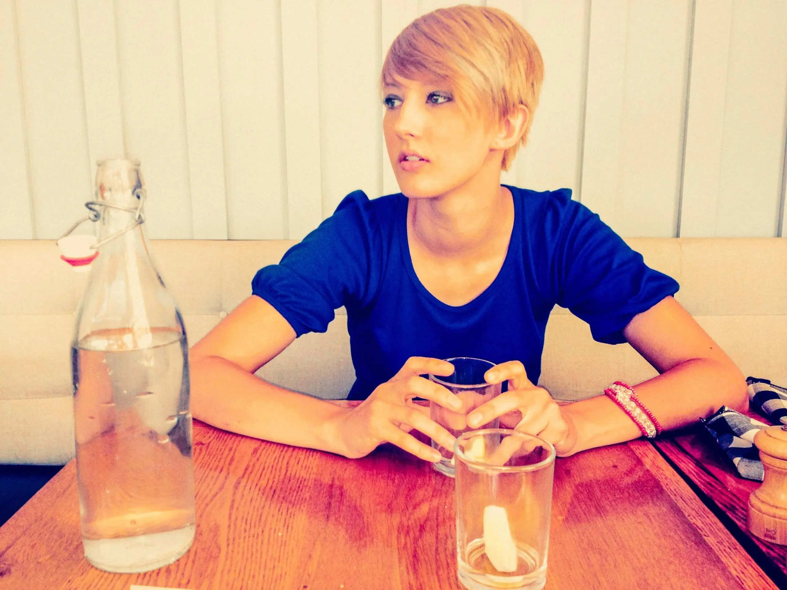 Woman sits at table with drink scaled