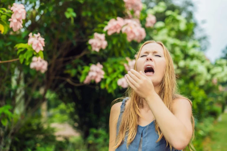 woman sneezes near flowers scaled