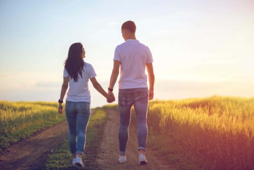 couple hold hands in sunset scaled