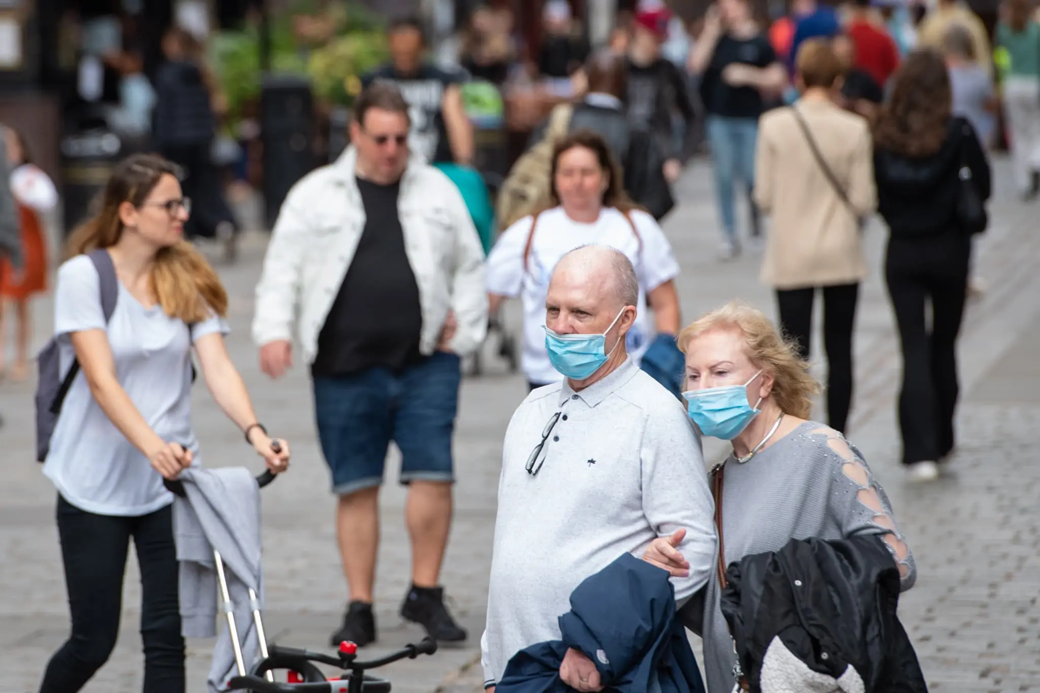 Couple wear facemask on busy high street