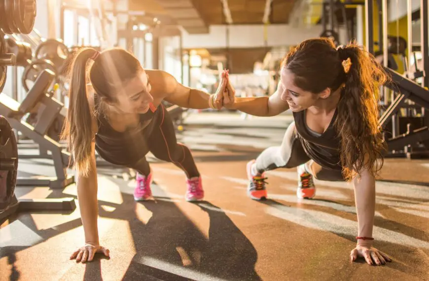fitness couple high five holding plank position scaled e1627986553591