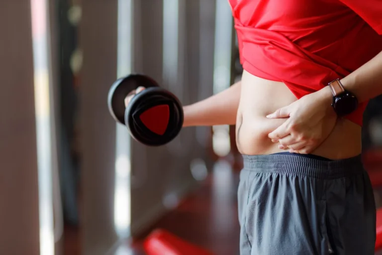 fitness goer pinches belly fat