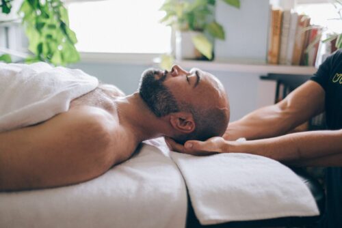 man lies on massage bed with head supported