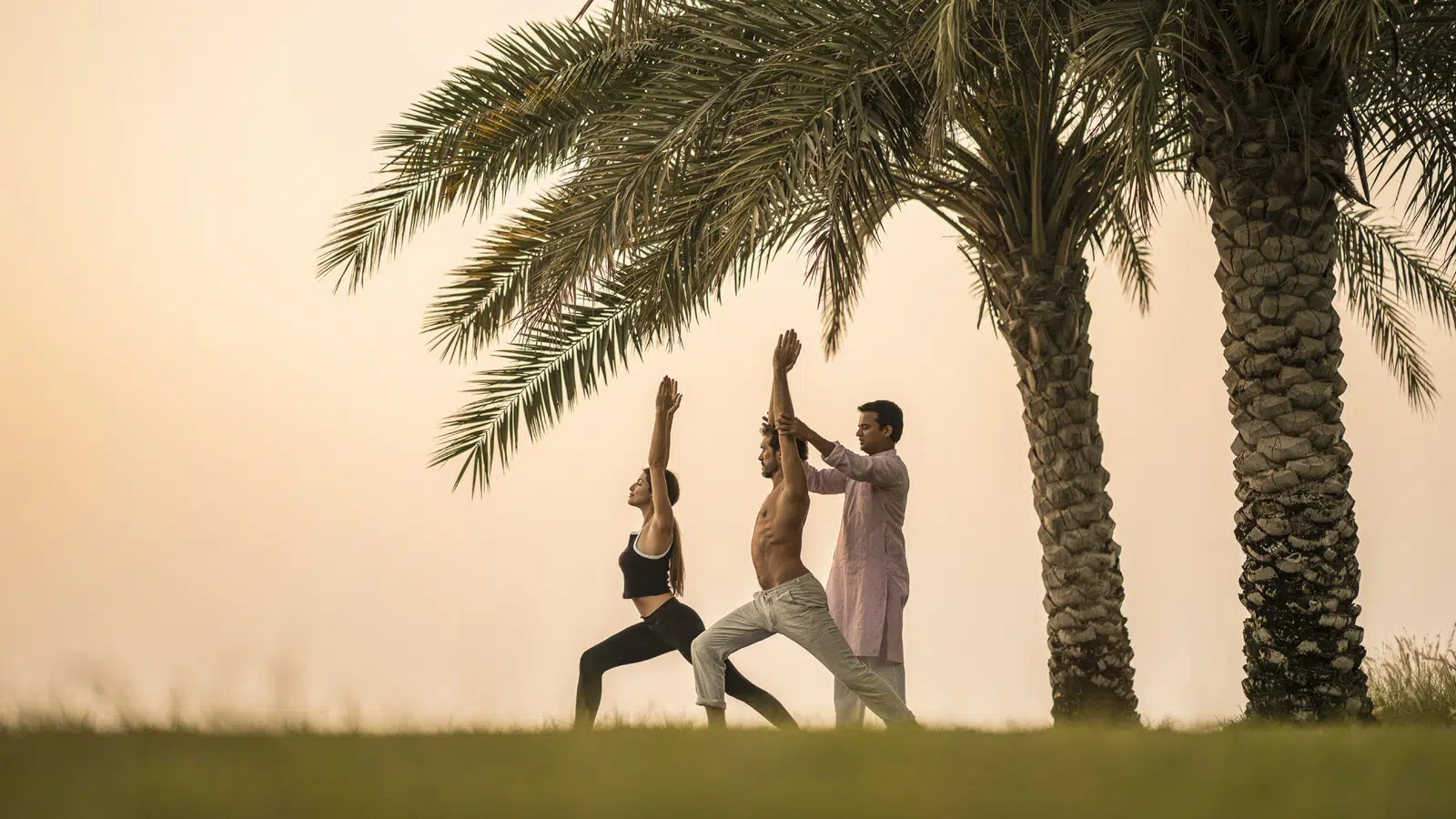 People practice yoga under a tree in bahrain bay