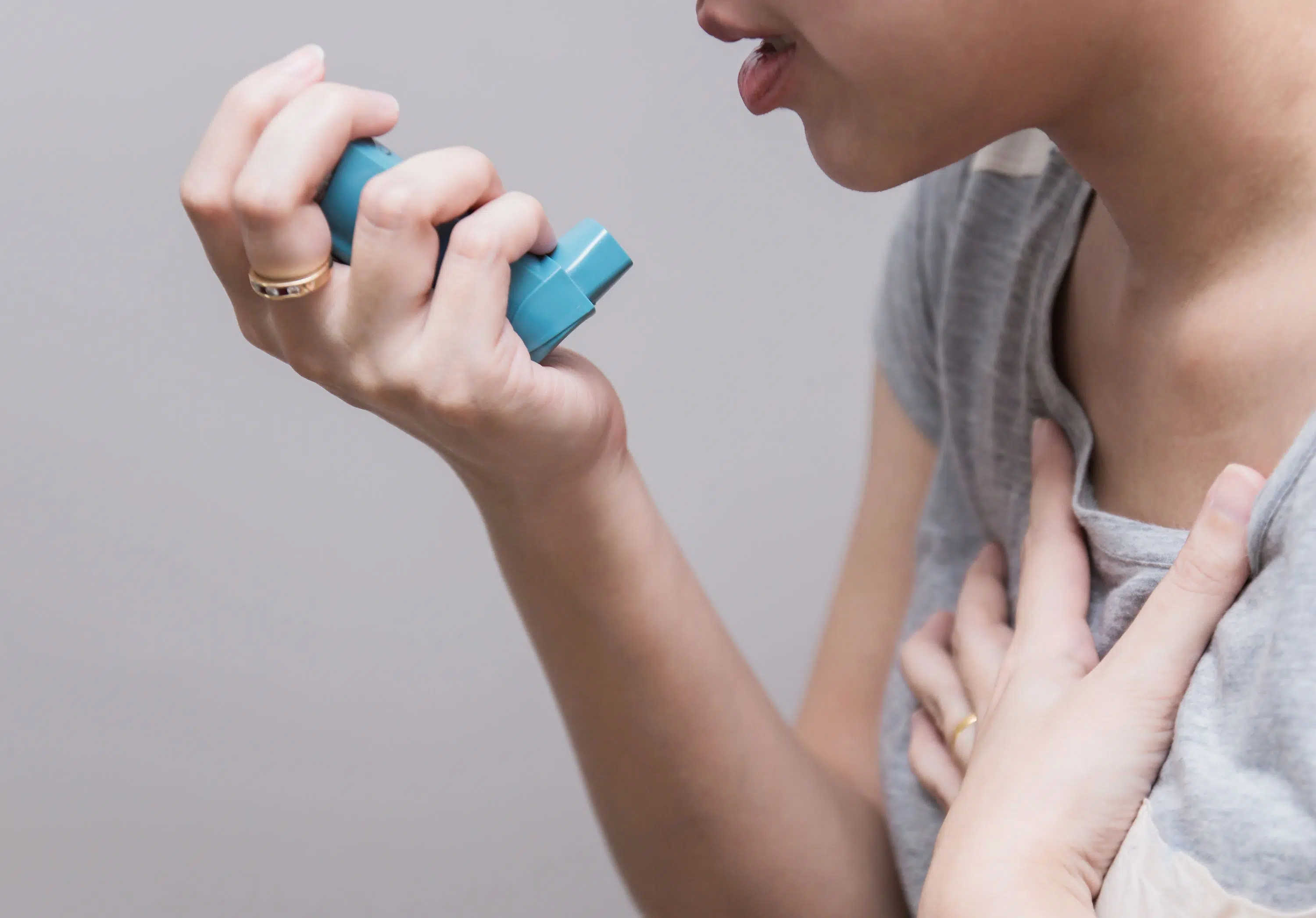 Person about to use asthma inhaler scaled