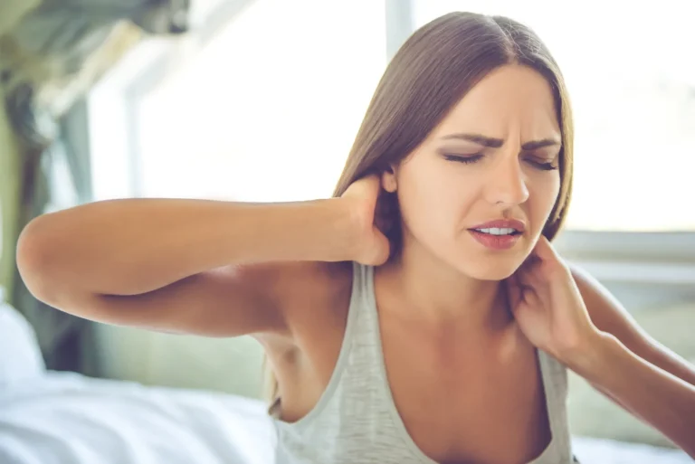 woman holds neck in pain