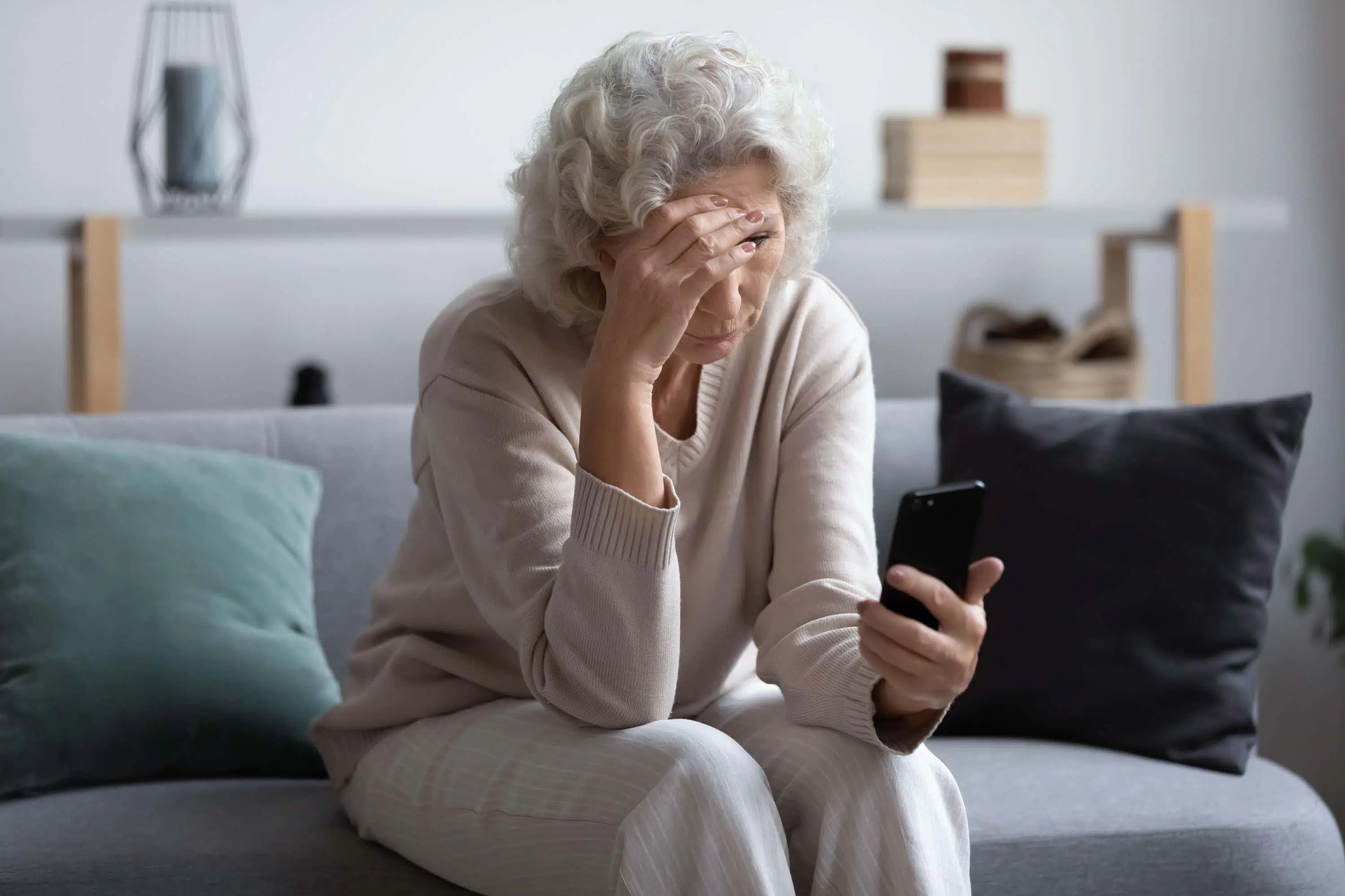 Woman looks stressed at her phone scaled