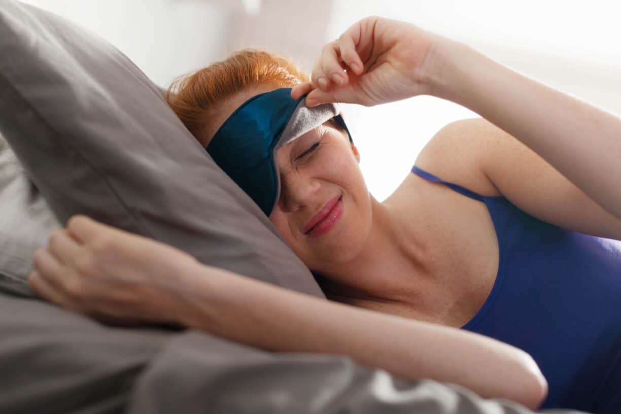 woman with sleep mask raised