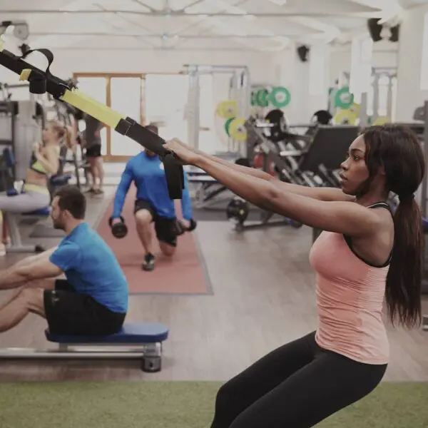 Woman working out with suspension trx in gym