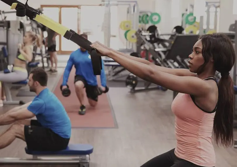 woman working out with suspension trx in gym