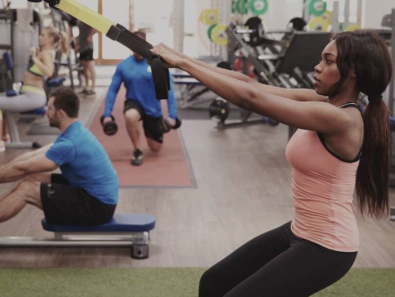 woman working out with suspension trx in gym